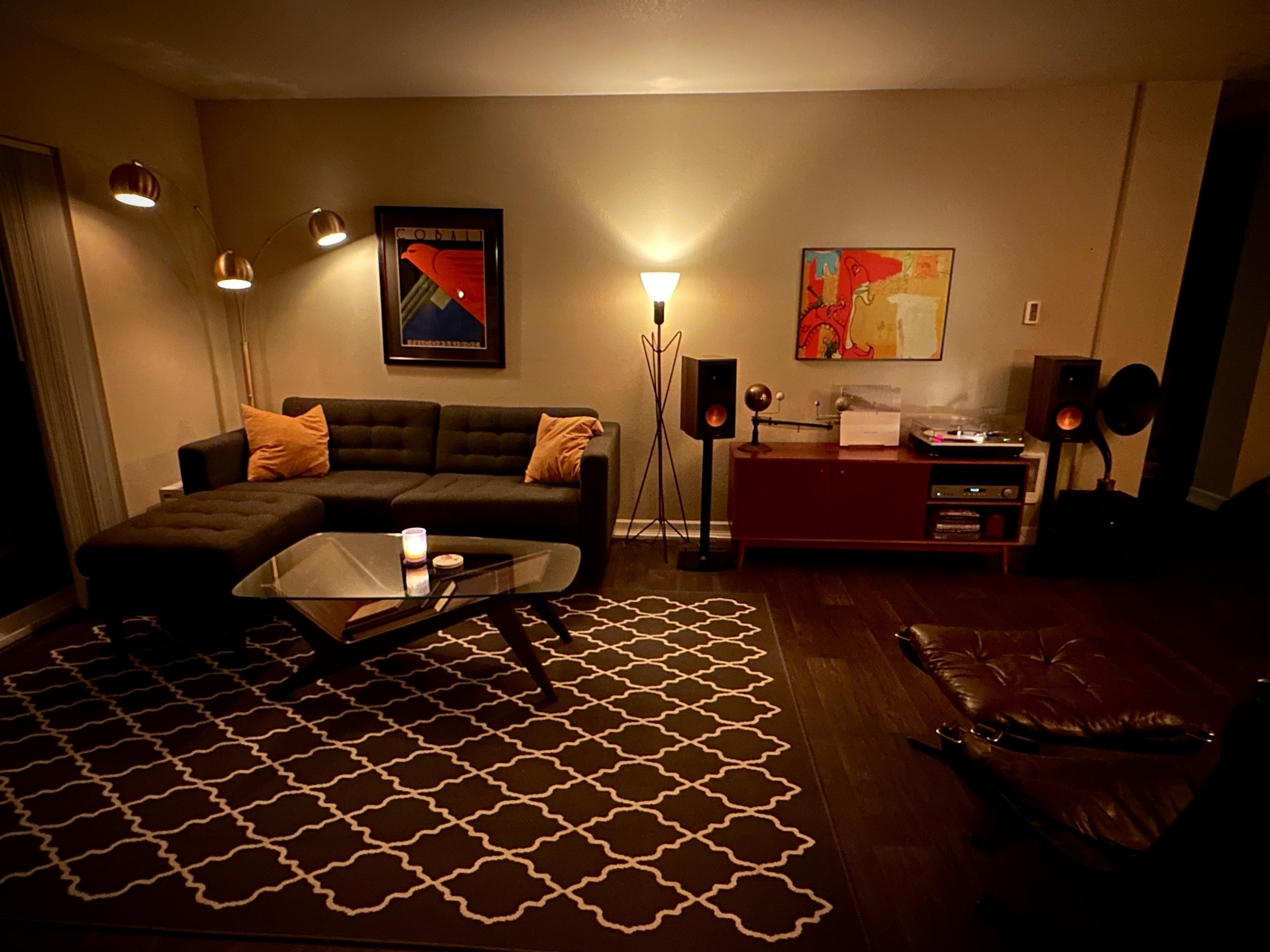 This living space design is the epitome of minimalistic mod. The warm colors and soft lighting create a cozy atmosphere that invites you to curl up on the couch and relax. The carefully chosen furniture pieces, such as the sleek couch and the stylish rug, tie the room together seamlessly. The bookshelf, with its hidden design, adds a touch of intrigue to the space. The cameras and antiques on display add a personal touch to the design, while the art deco pieces and painting above the bed bring a touch of elegance. Overall, this living space design is a perfect example of how minimalism can be both stylish and inviting. /2022_12_02_zaoq1f/k52hbeq04i3a1.jpg
